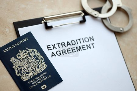 Pass Großbritanniens und Auslieferungsabkommen mit Handschellen auf dem Tisch