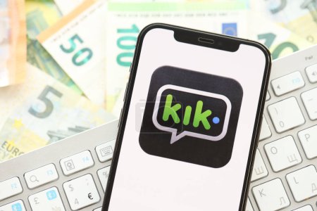 Photo for KYIV, UKRAINE - APRIL 1, 2024 Kik messenger icon on smartphone screen on many euro money bills. iPhone display with app logo with european currency euro banknotes and white keyboard - Royalty Free Image