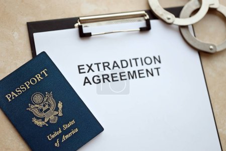 Reisepass der Vereinigten Staaten und Auslieferungsabkommen mit Handschellen auf dem Tisch