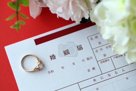Téléchargez les photos : Enregistrement de mariage japonais document vierge et bague de proposition de mariage et fleurs sur table close up - en image libre de droit