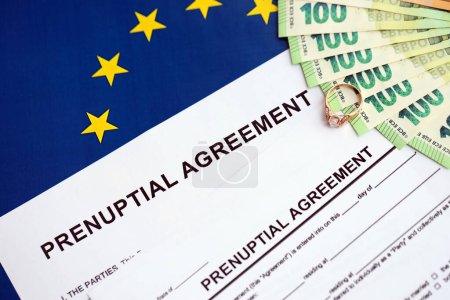 Accord prénuptial et alliance sur table. Processus de paperasserie prémaritale en Europe close up
