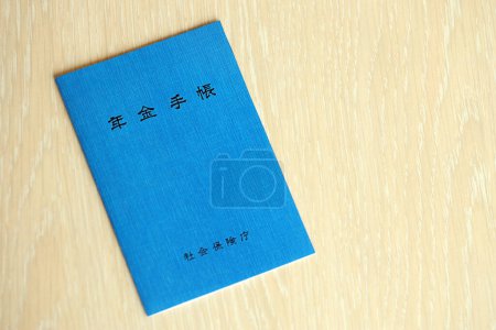 Japanese pension insurance booklet on table. Blue pension book for japan pensioners close up