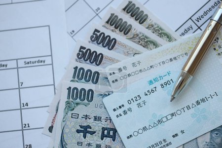 Téléchargez les photos : Japonais mon spécimen de carte de numéro et carte de notification sur fond de calendrier avec de l'argent de près - en image libre de droit