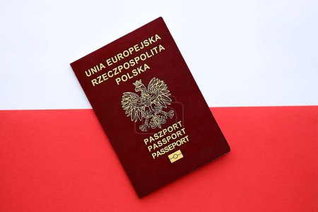 Pasaporte rojo pulido sobre bandera lisa roja y blanca de Polonia