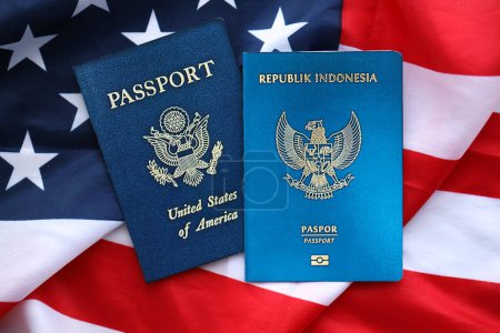Passport of Indonesia with US Passport on United States of America folded flag close up