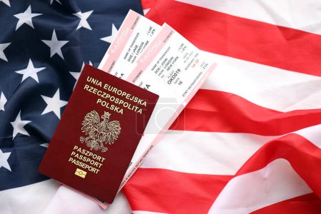 Polnischer Pass mit Flugtickets auf amerikanischer Flagge in Großaufnahme. Tourismus- und Reisekonzept