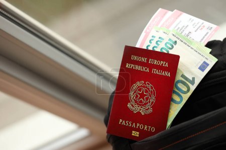 Italienischer Pass und Euro-Scheine mit Flugtickets im Rucksack in Nahaufnahme
