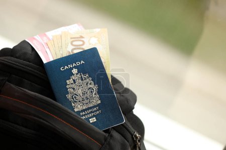 Kanadischer Pass und Dollarscheine mit Flugtickets im Rucksack aus nächster Nähe