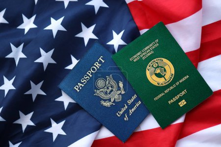 Téléchargez les photos : Passeport du Nigeria avec passeport américain sur drapeau plié des États-Unis d'Amérique gros plan - en image libre de droit