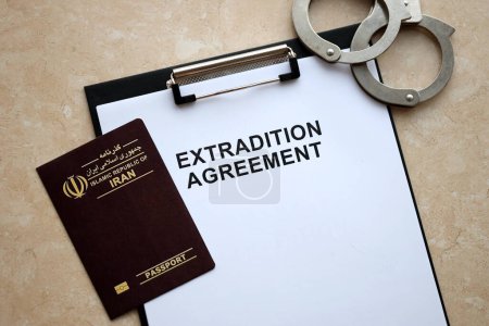 Téléchargez les photos : Passeport de l'Iran et accord d'extradition avec menottes sur la table close up - en image libre de droit