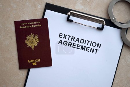 Téléchargez les photos : Passeport de France et accord d'extradition avec menottes sur la table close up - en image libre de droit