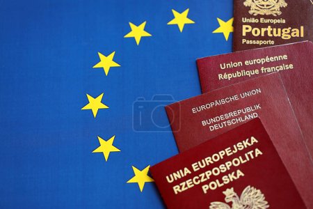 Foto de Los pasaportes de los países de la Unión Europea en bandera azul de la UE se cierran. Portugal, pasaportes alemanes, franceses y polacos - Imagen libre de derechos