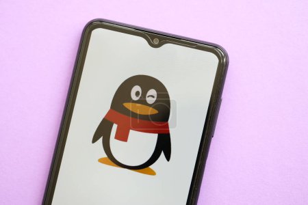 Téléchargez les photos : KYIV, UKRAINE - 1 AVRIL 2024 Tencent icône QQ sur l'écran du smartphone sur la table violette fermer. Écran iPhone avec logo app sur fond lilas - en image libre de droit