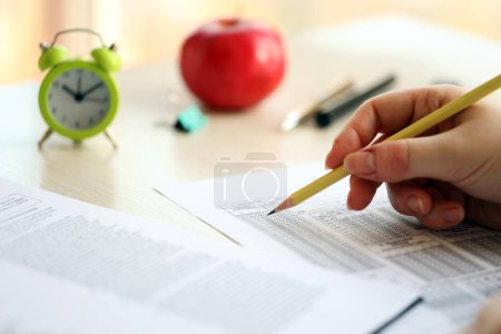 Studentinnen geben Prüfungsaufgaben ab und füllen Prüfungsbogen mit Bleistift im Schulprüfungsraum aus, Ausbildungskonzept