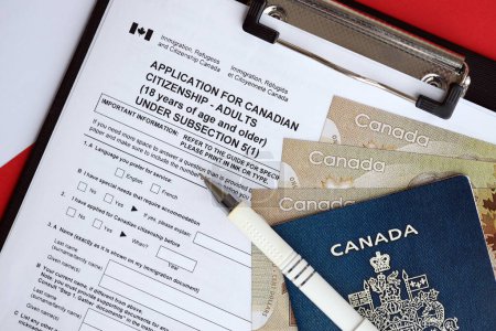 Téléchargez les photos : Demande de citoyenneté canadienne pour les adultes sur la table avec stylo, passeport et billets en dollars fermeture - en image libre de droit