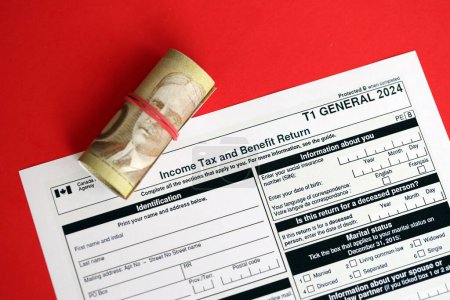 Canadian T1 Allgemeines Steuerformular Einkommensteuer und Leistungserklärung liegt auf dem Tisch, die kanadischen Geldscheine in Großaufnahme. Besteuerung und jährliche Buchhaltung in Kanada
