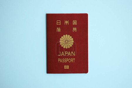 Pasaporte de Japón sobre fondo azul de cerca. Concepto de turismo y ciudadanía