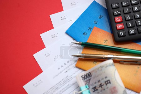 Foto de Folletos del seguro de pensiones japonés en la mesa con billetes de yen, pluma y calculadora en la mesa de primer plano - Imagen libre de derechos
