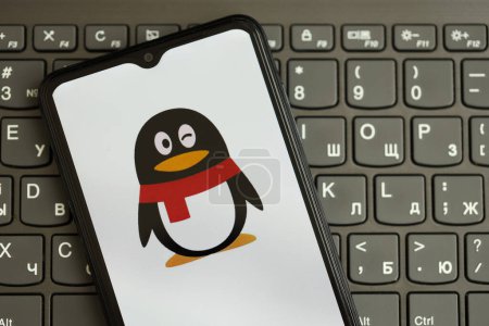 Téléchargez les photos : KYIV, UKRAINE - 1er AVRIL 2024 Tencent icône QQ sur l'écran du smartphone sur clavier noir fermer. Écran iPhone avec logo de l'application sur les boutons foncés du clavier - en image libre de droit