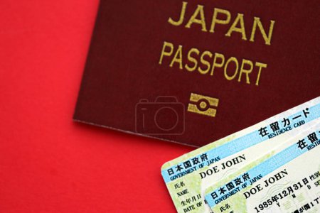 Photo for Green residence card of Japan with passport on red background close up - Royalty Free Image