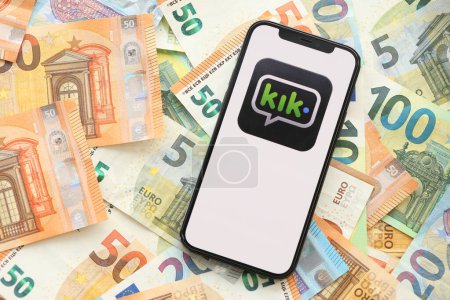 Photo for KYIV, UKRAINE - APRIL 1, 2024 Kik messenger icon on smartphone screen on many euro money bills. iPhone display with app logo with european currency euro banknotes - Royalty Free Image