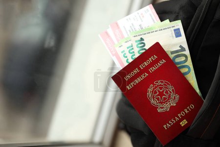 Italienischer Pass und Euro-Scheine mit Flugtickets im Rucksack in Nahaufnahme