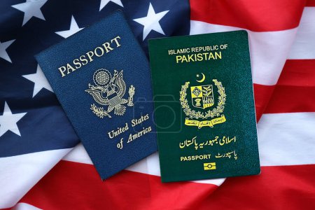 Reisepass Pakistans mit US-Pass auf gefalteter Flagge der Vereinigten Staaten von Amerika in Großaufnahme
