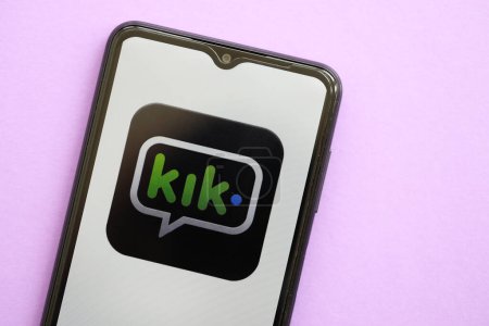 Photo for KYIV, UKRAINE - APRIL 1, 2024 Kik messenger icon on smartphone screen on purple table close up. iPhone display with app logo on lilac background - Royalty Free Image