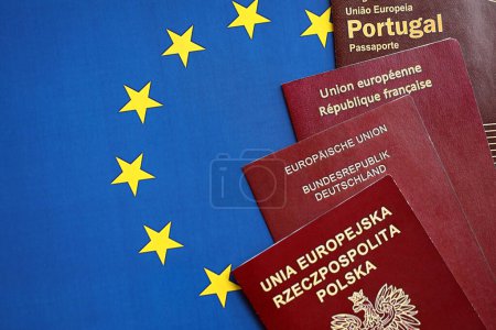 Foto de Los pasaportes de los países de la Unión Europea en bandera azul de la UE se cierran. Portugal, pasaportes alemanes, franceses y polacos - Imagen libre de derechos