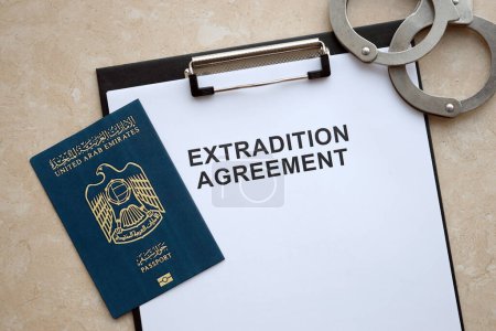 Passeport des Émirats arabes unis et accord d'extradition avec menottes sur la table close up