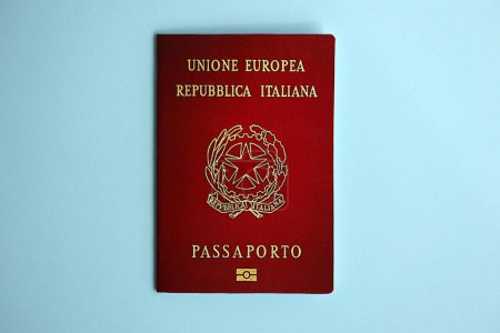 Passeport italien sur fond bleu rapproché. Concept de tourisme et de citoyenneté