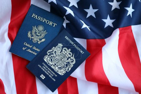 Pasaporte de Gran Bretaña con pasaporte estadounidense en Estados Unidos de América plegado bandera de cerca
