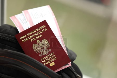 Poland passport with airline tickets on touristic backpack close up. Tourism and travel concept