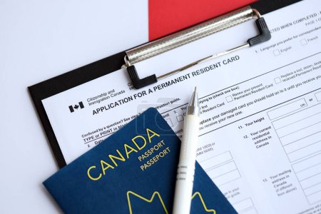 Antrag auf Daueraufenthaltskarte auf dem Tisch mit Stift und kanadischem Pass aus nächster Nähe