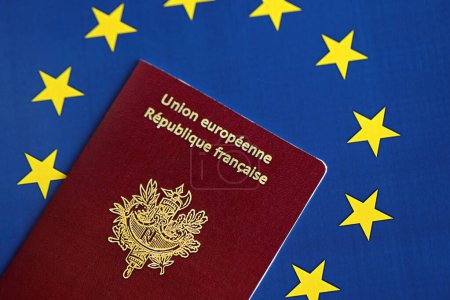 French passport of European Union on blue flag background close up. Tourism and citizenship concept