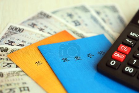 Folletos de seguros de pensiones japoneses en la mesa con billetes de yenes y calculadora en la mesa de primer plano