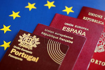 Foto de Los pasaportes de los países de la Unión Europea en bandera azul de la UE se cierran. Pasaportes de Portugal, España, Francia e Italia - Imagen libre de derechos