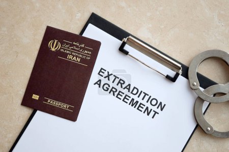 Passport of Iran and Extradition Agreement with handcuffs on table close up
