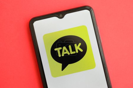 Photo for KYIV, UKRAINE - APRIL 1, 2024 KakaoTalk messenger icon on smartphone screen on red table close up. iPhone display with app logo on bright red background - Royalty Free Image