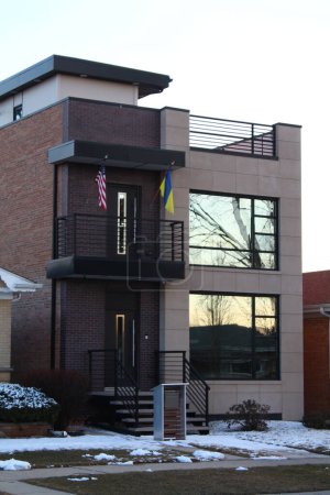 moderna casa contemporánea de dos pisos en un barrio con una bandera estadounidense y una bandera ucraniana