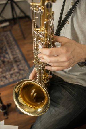 Téléchargez les photos : Mains d'un musicien jouant du saxophone dans une salle de répétition - en image libre de droit