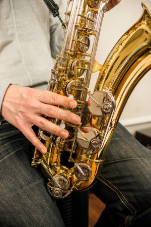 Téléchargez les photos : Mains d'un musicien sur un saxophone doré et métallique - en image libre de droit