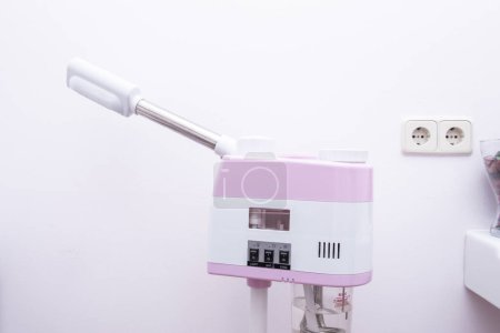 Téléchargez les photos : Une machine à rouleaux rose et blanc pour appliquer des traitements dans un centre de beauté - en image libre de droit