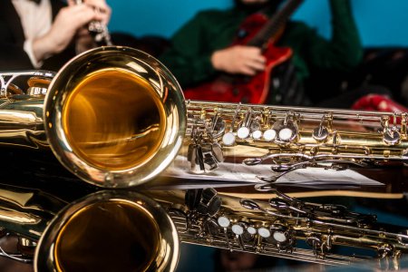 Téléchargez les photos : Un saxophone doré et argenté sur une table en miroir - en image libre de droit
