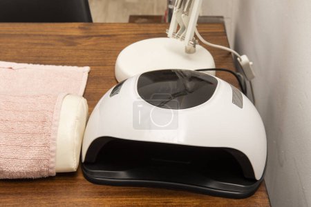 Téléchargez les photos : Simple electric machine for drying nail polish on hands in a beauty salon - en image libre de droit