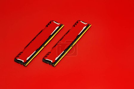 Photo for Some crossed ddr4 ram memory modules with red metallic heat sinks on a smooth red surface - Royalty Free Image