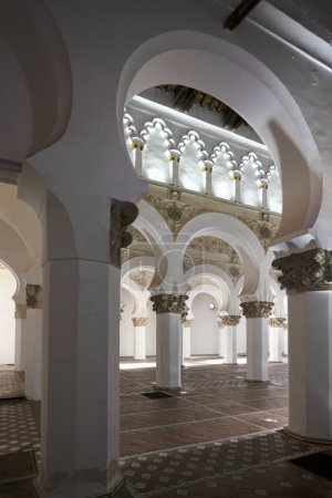 Foto de Arcos de la sinagoga de Toledo con paredes encaladas, suelos de barro y techos antiguos de madera - Imagen libre de derechos