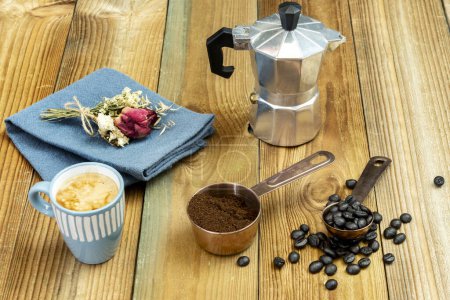 Foto de Un bodegón con café tostado, café molido en una cacerola de cobre, un expreso en una taza azul y una pequeña cafetera - Imagen libre de derechos