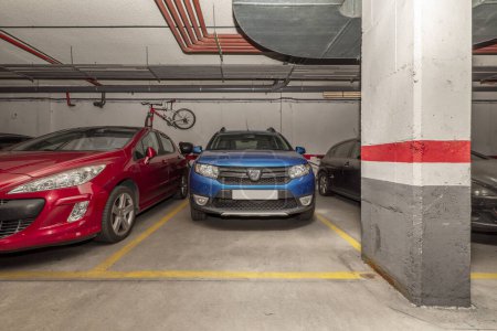 Téléchargez les photos : Véhicules stationnés dans un parking souterrain d'un immeuble résidentiel urbain - en image libre de droit