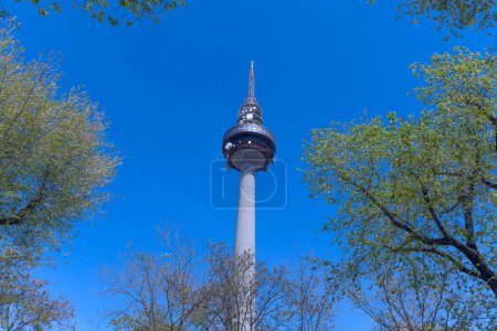 Téléchargez les photos : Tour de télécommunications à Madrid avec un cadre de branches d'arbres avec des feuilles et un peu de ciel bleu - en image libre de droit